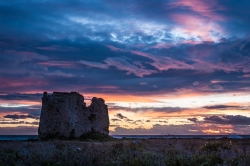 "Torre Sgarrata" (broken tower) ,Taranto province, Apulia, Italy, at sunset with a very colorful sky.